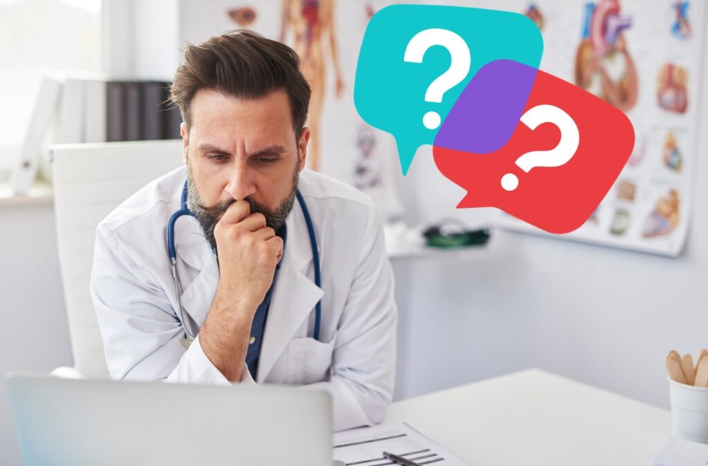 Medical professional looking at a laptop with question marks around him